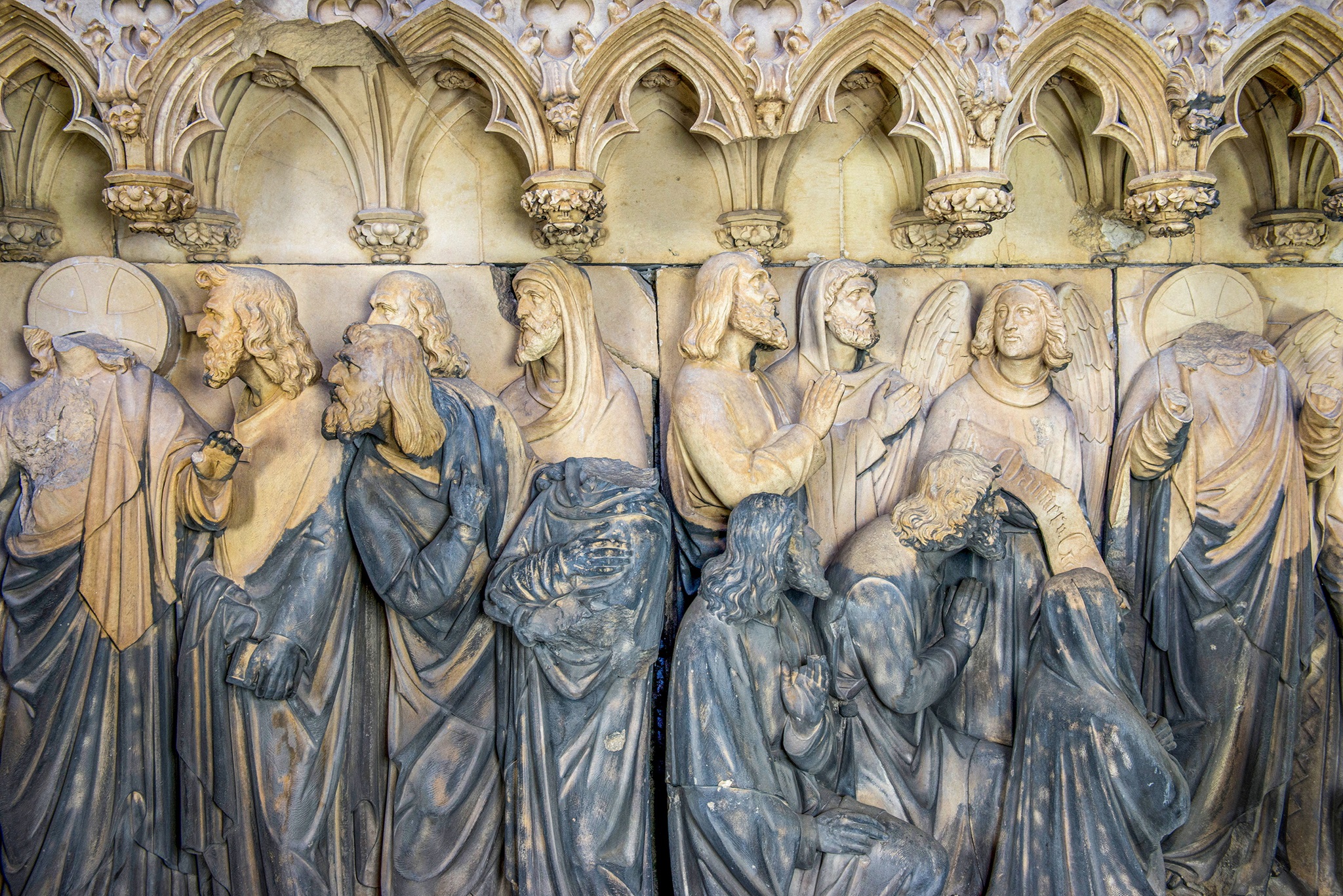 Relief des Kölner Doms mit den durch Laserstrahl entfernten Gipskrusten, gereinigte Bereiche mit Figuren sind hell, schmutzige sind dunkel.